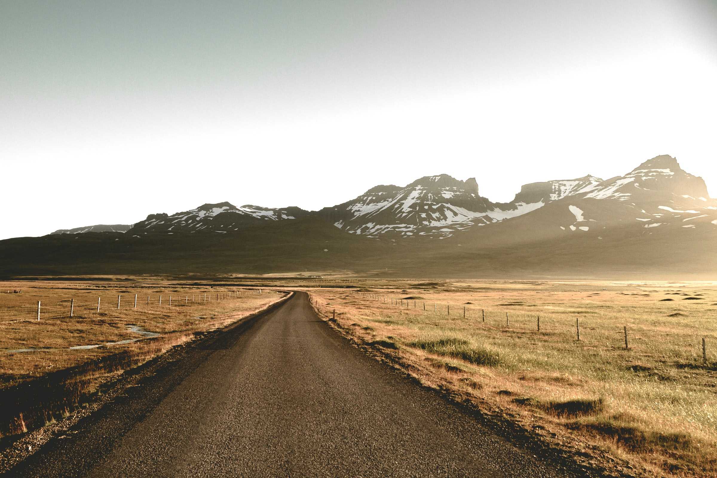 A gravel road at the foot of a mountain range