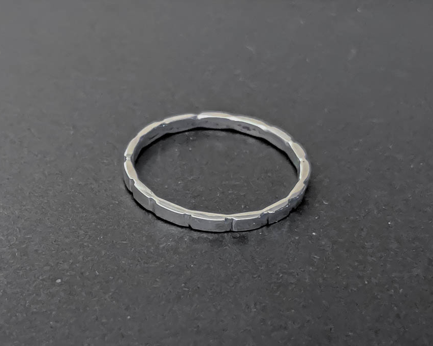Thin sterling silver stacking ring with larger cuts in the ring surface